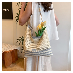 Detail view of woven shoulder bag featuring hollow knit texture and wooden bead chain strap
