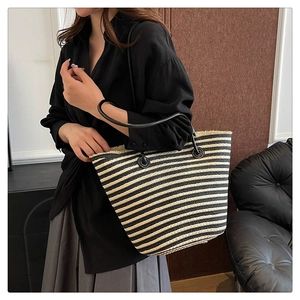 Détail du sac cabas tissé à rayures avec bandoulières en cuir et œillets en métal