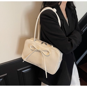 Close-up of the large bow detail and soft cream leather texture on the Boston shoulder bag
