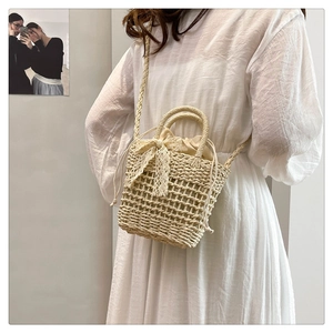Detail of beige woven bucket bag with lace bow and drawstring liner in resort style