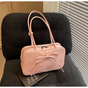 Close-up of pink Boston bag featuring a slender bow detail and smooth PU leather finish