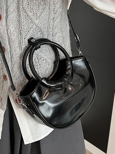 Glossy black half-moon bucket bag with circular handles and detachable shoulder strap