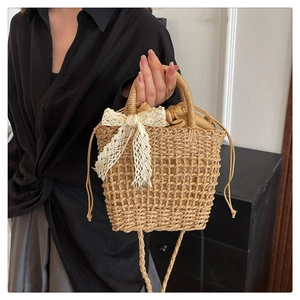 Close-up of woven straw handbag with hollow texture and elegant white lace bow detail