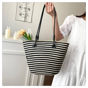 Détail du sac cabas tissé à rayures noires et blanches avec de longues anses fines noires
