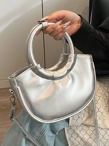 Chic silver half-moon handbag with a circular handle and detachable crossbody strap