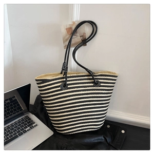 Détail du sac cabas tissé à rayures noires et blanches avec franges et anses en cuir