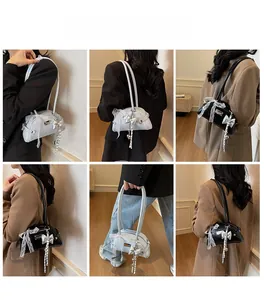 Détail du ruban à nœud et du pendentif cœur argenté sur un sac à main pour femme