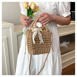 Close-up of woven straw bag detail with delicate white lace bow and drawstring lining