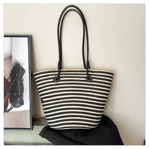 Détail d'un sac cabas tissé à rayures noires et blanches avec de longues bandoulières