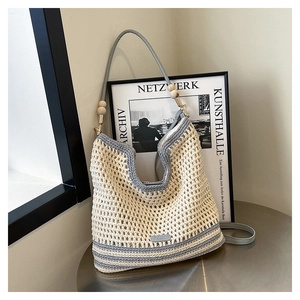 Close-up of contrast hollow crochet bag with leather strap and decorative wood beads