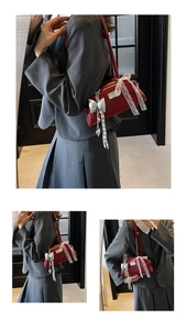 Détail du sac à bandoulière en cuir verni rouge avec nœud en dentelle et chaîne perle