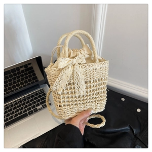 Close-up of beige woven straw bag with lace bow and secure inner drawstring pocket