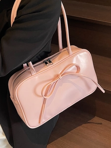 Pink glossy ballet-style Boston bag with a large bow detail shown in a stylish profile view