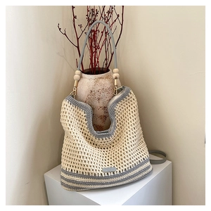 Close-up of contrast woven tote bag showing neutral cotton texture and wooden bead accents