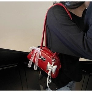 Sac bowling rouge en cuir avec nœud en dentelle blanche et breloque cœur sur la bandoulière