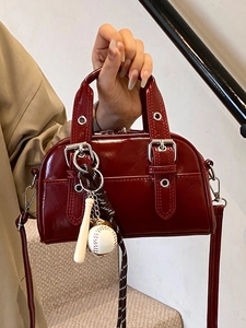 Dark red patent leather Boston bag with silver hardware and baseball keychain accessory