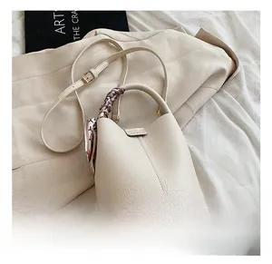 Detail showing cream white lychee leather bucket bag with printed silk scarf handle accessory