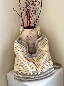 Handcrafted hollow woven tote bag with gray trim, wooden beads, and leather handles