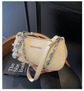Détail du sac à main en similicuir blanc cassé avec chaîne argentée et bijou de sac