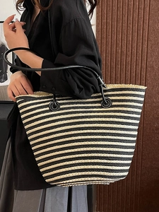 Sac cabas rayé en paille avec bandoulières noires et franges pour la plage d'été