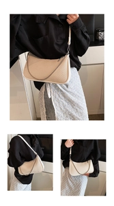 Close-up of cream PU underarm bag with diagonal embossed texture and silver chain strap