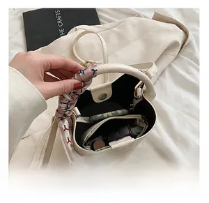 Interior view of cream bucket bag with silk scarf handle showing spacious storage capacity