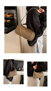 Detail of khaki woven texture handbag featuring decorative silver chain and sleek zipper