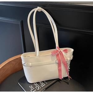 Détail du sac cabas blanc en cuir ciré avec nœud à carreaux et pendentif cœur