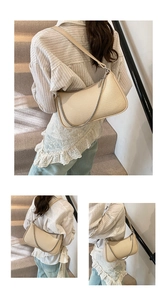 Detail of beige textured underarm bag with silver chain strap and metal zipper