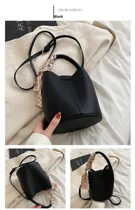 Detailed macro view of black lychee grain bucket bag with decorative silk scarf handle