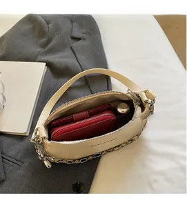 Vue intérieure du sac à main en cuir crème montrant la capacité avec un portefeuille