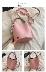 Detail of pink lychee textured bucket bag featuring decorative silk scarf and logo