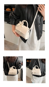 Detail of creamy white crossbody bag featuring pebble leather texture and floral scarf handle