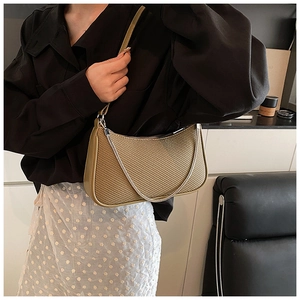 Detail of olive green baguette bag with diagonal weave texture and metal chain accent
