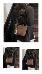 Detail of a brown embossed bucket bag with graffiti patterns and cartoon charm on a strap