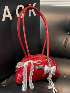 Sac Boston rouge brillant avec nœud en dentelle blanche et pendentifs argentés
