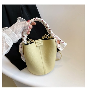 Detail of lime green bucket bag with lychee texture and silk scarf wrapped handle