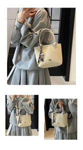 Detail of cream white tote bag with cartoon embossed pattern and cute bear charm