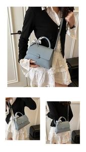 Detail of light blue lychee texture leather bag with silk scarf handle and metal clasp