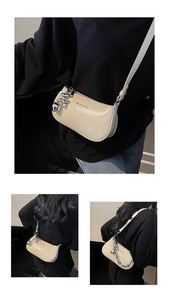Détail du sac demi-lune crème en cuir avec chaîne argentée et pendentif chien ballon