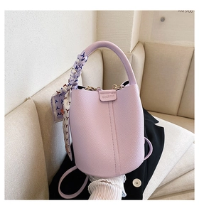 Detail of lavender lychee leather bucket bag with printed silk scarf handle decoration