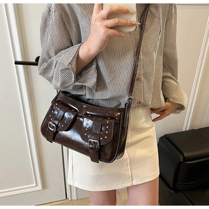 Mirror selfie showing the dark brown retro Y2K crossbody bag with silver rivet details