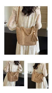 Detail of woven straw tote bag featuring brown leather strap and wood bead tassel