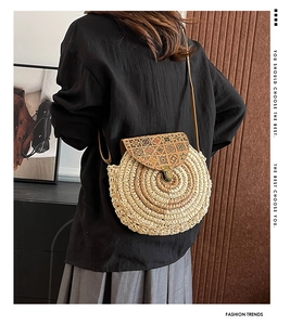 Detail of round straw crossbody bag with geometric floral pattern and vintage metal lock