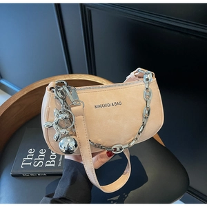 Détail d'un sac demi-lune rose avec chaîne argentée et breloque chien ballon chic