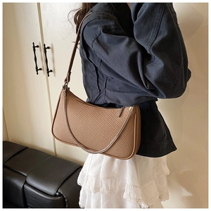 Brown woven texture shoulder bag worn by model showing minimalist retro fashion style