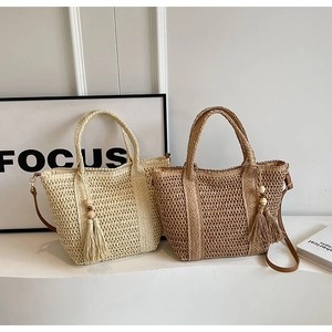 Detailed close-up of woven tote bag texture with elegant tassel and wooden bead
