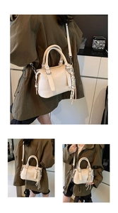 Detailed view of cream PU leather bag with top handles, ENJOY embossing and striped scarf decoration