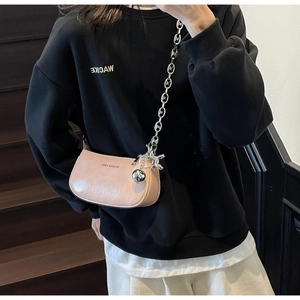 Détail du sac baguette rose clair avec chaîne argentée et pendentif chien ballon