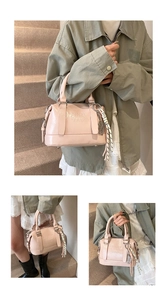 Detail of light pink Boston bag featuring text embossing and decorative silk scarf